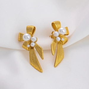 Elegant 18K gold plated stainless steel bow earrings with pearls on white silk fabric