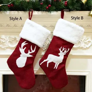 Chaussettes de Noël en toile rouge avec broderie d'élan sur cheminée blanche