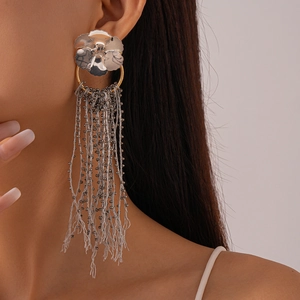 Detailed view of silver flower earrings with beaded tassels on a model's ear