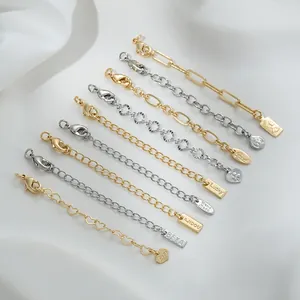 Detailed macro of various 14K gold-filled and silver extension chains with lucky tags