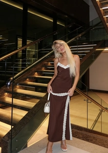 Detailansicht des braunen Satin-Trägerkleids mit weißem Spitzenbesatz und Beinschlitz