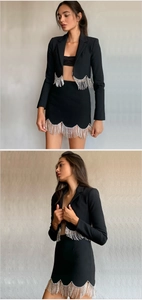 Detailed view of women's black two-piece suit with shimmering silver tassel trim