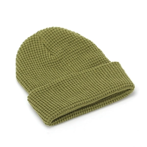 Close-up of olive green waffle knit beanie showing thick texture and folded cuff detail