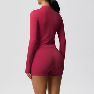 Rear view of a tight berry red yoga set with long sleeve zipper top and high waist shorts