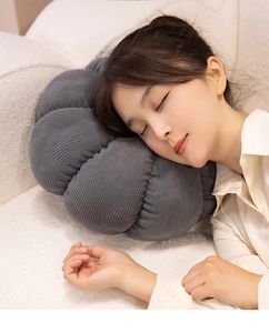 Détail d'un coussin citrouille en velours côtelé gris foncé utilisé par un mannequin femme