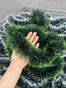 Detail of 2M dark green Christmas tinsel garland with white edges for festive decoration
