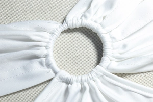 Gros plan d'une robe en maille blanche avec anneau central et détails de fronces