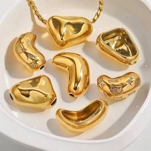 Golden irregular stainless steel charms in a white dish with artistic engravings