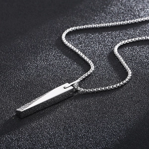 Macro detail of silver CNC pendant with matte frosted texture and polished steel surfaces