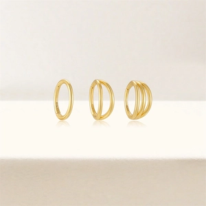 Detailed view of three gold S925 sterling silver hoop earrings with triple crystal accents