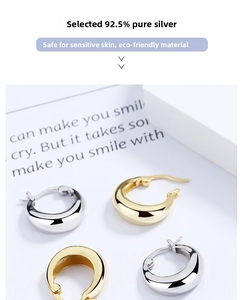 Detail of chunky drop hoop earrings in gold and silver S925 sterling silver material
