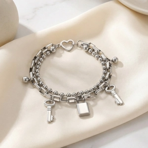 Detailed close-up of silver titanium double-layered bracelet with heart lock and key charms