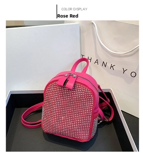 Detail of rose red mini backpack featuring silver studs and gift packaging set