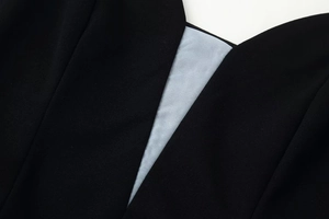 Detailed macro shot of fine fabric texture and stitching on a black V-neck dress