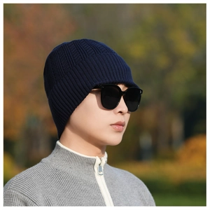 Detail of navy blue winter knit beanie with brim featuring thick texture for cold weather