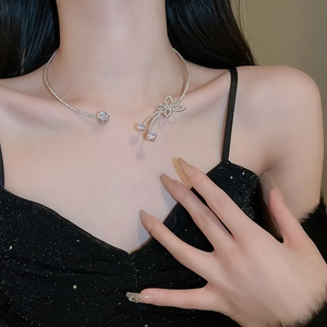 Detail of silver butterfly choker with zircon stones and tassel pendant on neck