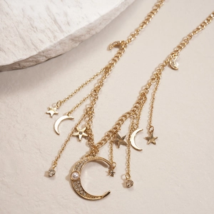 Détail du collier à pampilles lune et étoile dorée avec strass brillants et perles