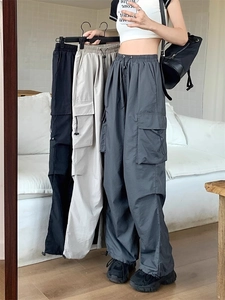 Detail of high-waisted cargo pants with side pockets and adjustable drawstring hem