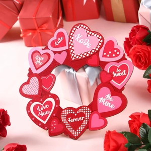 Macro detail of red and pink wooden heart wreath with romantic XOXO and Love You messages