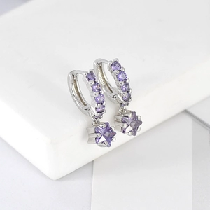 Close-up of silver earrings with purple zircon stars on a white display stand