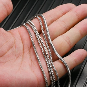Detalle de cadenas de acero de titanio plateado incluyendo estilos de serpiente y caja