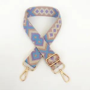 Detail of bohemian geometric purple and blue canvas bag strap with golden metal hooks