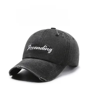 Close-up of distressed baseball cap with white Ascending embroidery and torn fabric detail