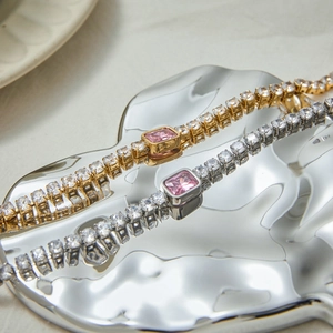 Detailed close-up of gold and silver tennis bracelets with pink rectangular crystals