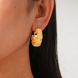 Detailed view of 24k gold-plated irregular pleated hoop earrings in a woven nest design
