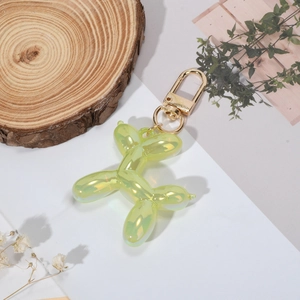 Rainbow lime green balloon dog keychain with golden metal clasp on white background