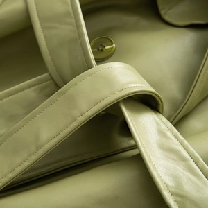 Detailed macro view of avocado green leather jacket with double stitching and tonal button