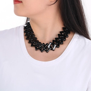 Gros plan d'un collier hip hop noir de 32 mm d'épaisseur en forme d'os sur un modèle
