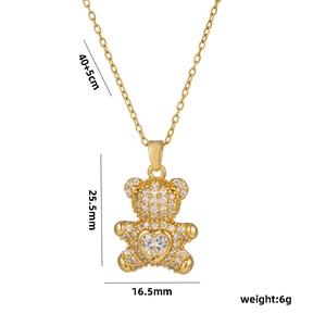 Golden teddy bear necklace with heart zircon pendant and size specs on white background