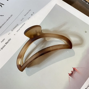 Detail of a large matte amber brown hair claw clip with a resin translucent texture