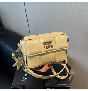 Détail du sac bandoulière tissé crème en similicuir avec chaîne et étoile argentée