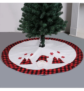 Detail of white Christmas tree skirt with Santa Claus motif and red black plaid borders