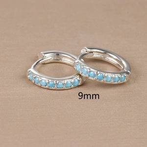 Detail shot of 9mm silver hoop earrings featuring a small round blue zircon stone