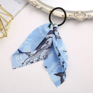 Detail shot of light blue floral ribbon hair scrunchie with elastic band and vintage print