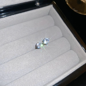 Macro shot of brilliant round cut zircon earrings in silver finish inside a velvet box