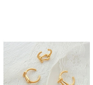 Vue détaillée de trois ear cuffs dorés texture bambou sur dentelle et plateau céramique