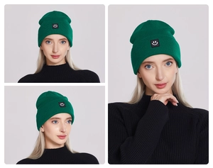 Detail of neon green ribbed knit beanie with a smiley face patch worn by a model