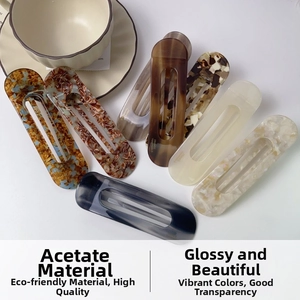 Close-up of elegant tortoiseshell and marble acetate hair clips with镂空 design detail