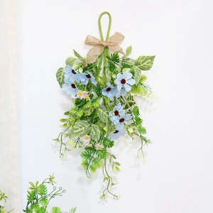 Detail of light blue daisy wall hanging with rustic linen bow and greenery for decor