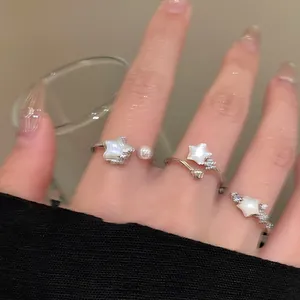 Detail of star-themed rings featuring pearl and zircon accents on a silver metal band