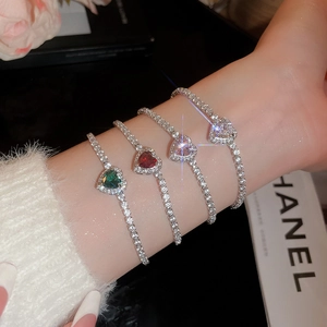 Close-up of four luxury heart-shaped zircon tennis bracelets in emerald and ruby colors