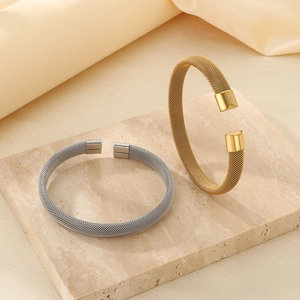 Vista dettagliata della trama intrecciata su bracciali aperti in oro 18K e argento