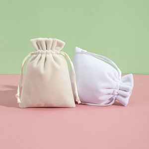 Plush velvet drawstring jewelry pouches in beige and white for gift packaging