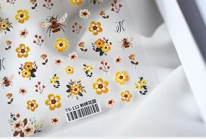Macro shot of 5D embroidered flower nail stickers with bees and green leaves on TS-112