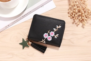 Close-up of black PU leather wallet with floral embroidery, fringe and star charm