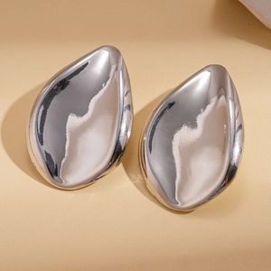 Macro shot of polished silver water drop earrings with high-gloss metallic finish